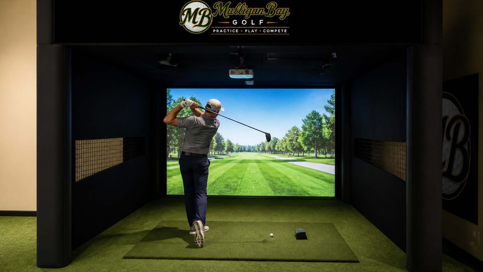 A golfer hitting a shot inside the Bay 3 enclosure